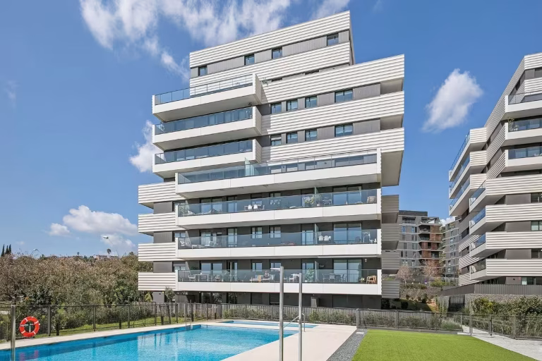 Exterior edificio con piscina del proyecto de instalaciones integrales en promoción residencial en Finestrelles por Benmitsu